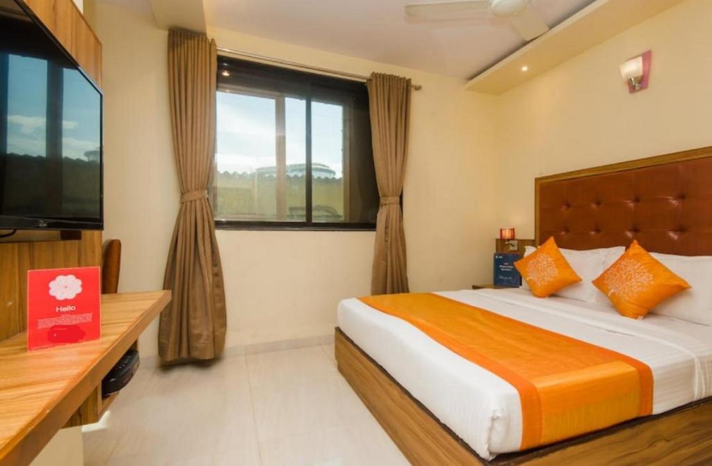 孟买Aster Hotel Near Mumbai Airport的一间卧室设有一张大床和一个窗户。