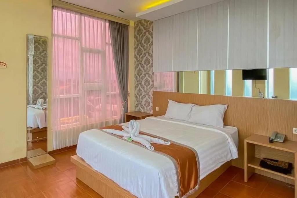 玛琅De Malang Sweet Homestay Syariah Mitra RedDoorz的一间卧室设有一张大床和一个窗户。
