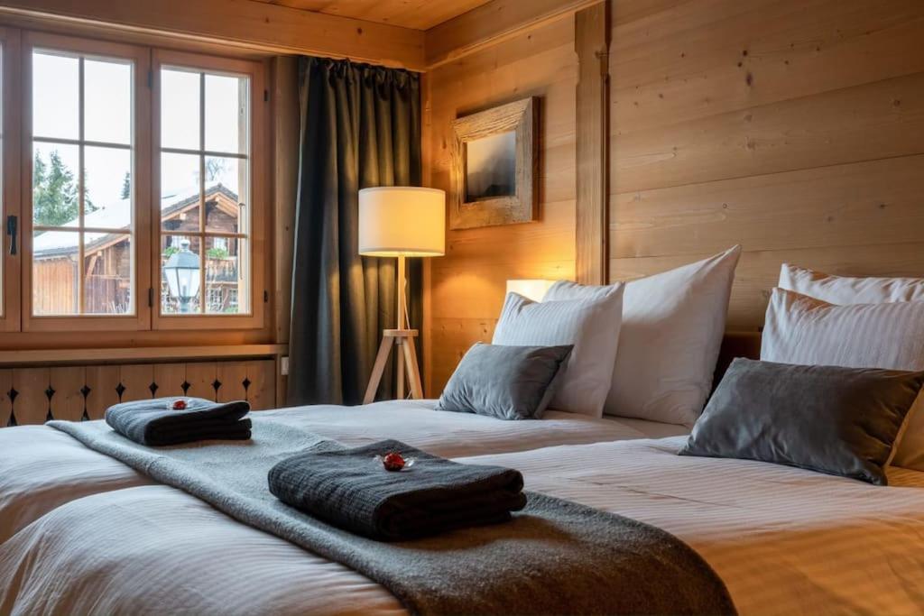 格施塔德Charming Alpine Apartment Gstaad的一间卧室配有两张带毛巾的床