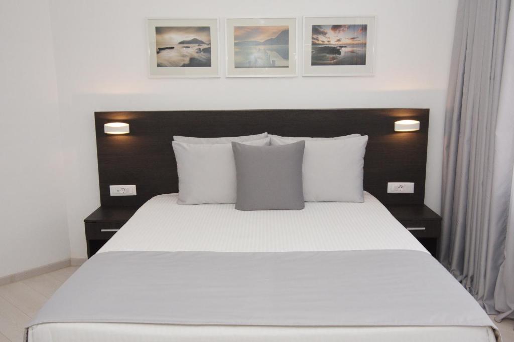 雅典International Atene hotel的卧室配有一张带白色床单和枕头的大床。
