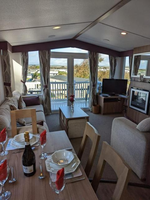 韦茅斯Caravan Littlesea Haven Weymouth Amazing Views的客厅配有带酒杯的桌子