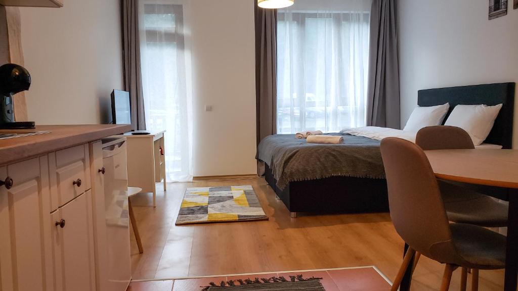 波罗维茨Semiramida Gardens Apartments的一间卧室配有一张床、一张桌子和一张桌子