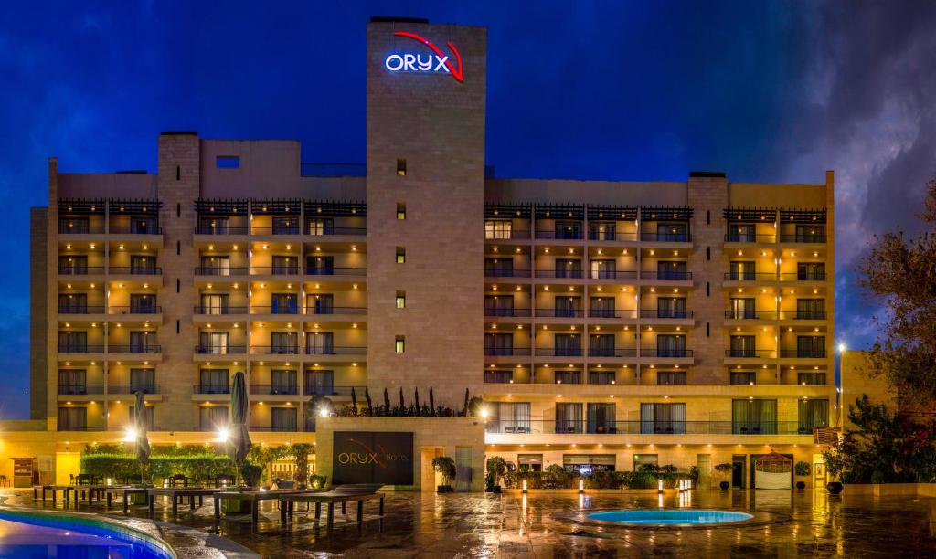 亚喀巴Oryx Hotel Aqaba的建筑顶部有标志的酒店