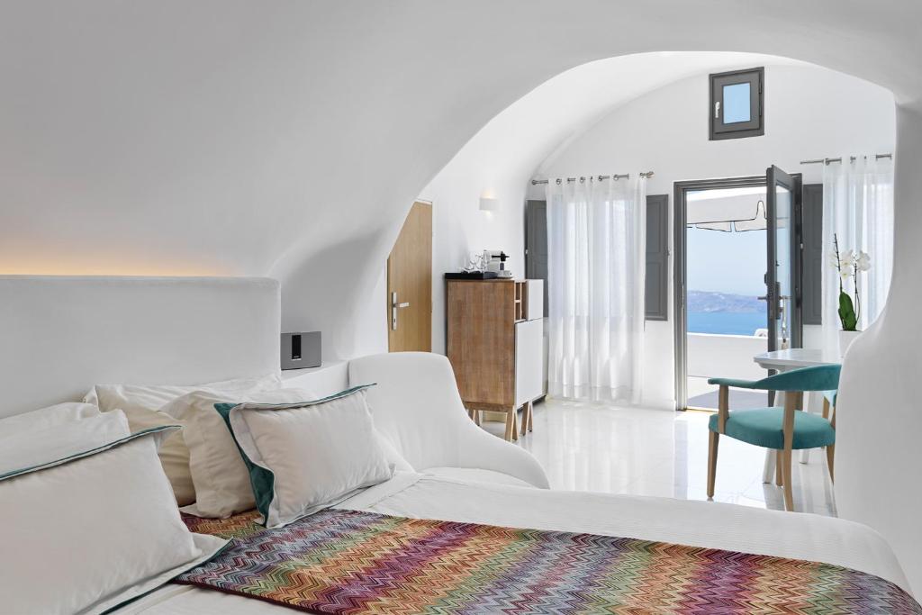 易莫洛林Katikies Chromata Santorini - The Leading Hotels of the World的白色的客房配有白色的沙发和桌子