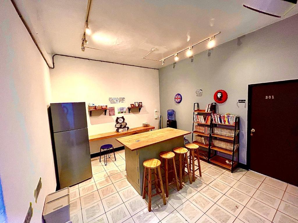 台东日寺光胶囊的厨房配有柜台、冰箱和凳子