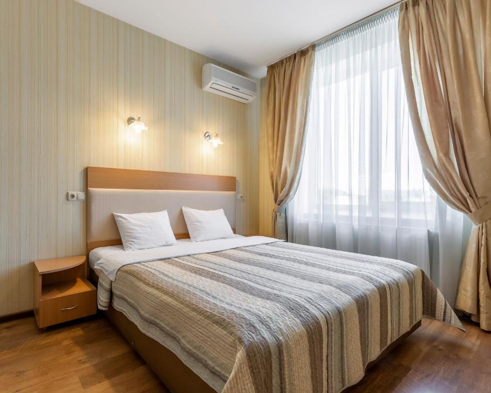 基辅Гостиница Siesta Киев的一间卧室设有一张大床和一个窗户。