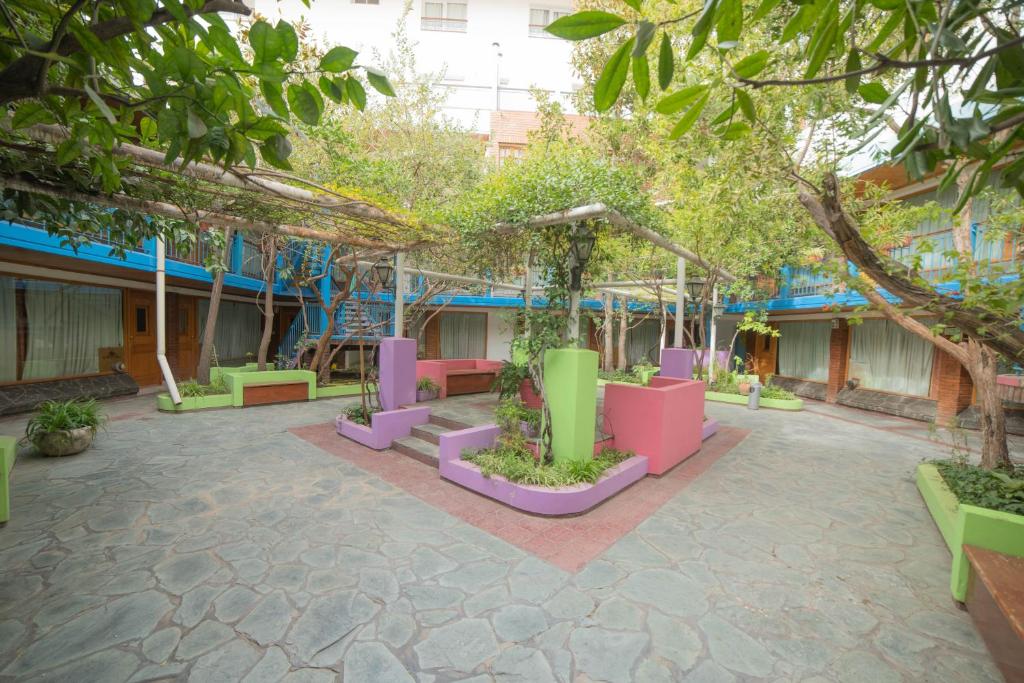 内乌肯El Prado的一座庭院,在一座建筑前方有五颜六色的长椅和树木
