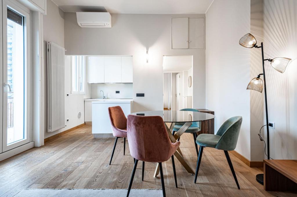 米兰Montello Livings, Exclusive terrace and skyline view的厨房以及带玻璃桌和椅子的用餐室