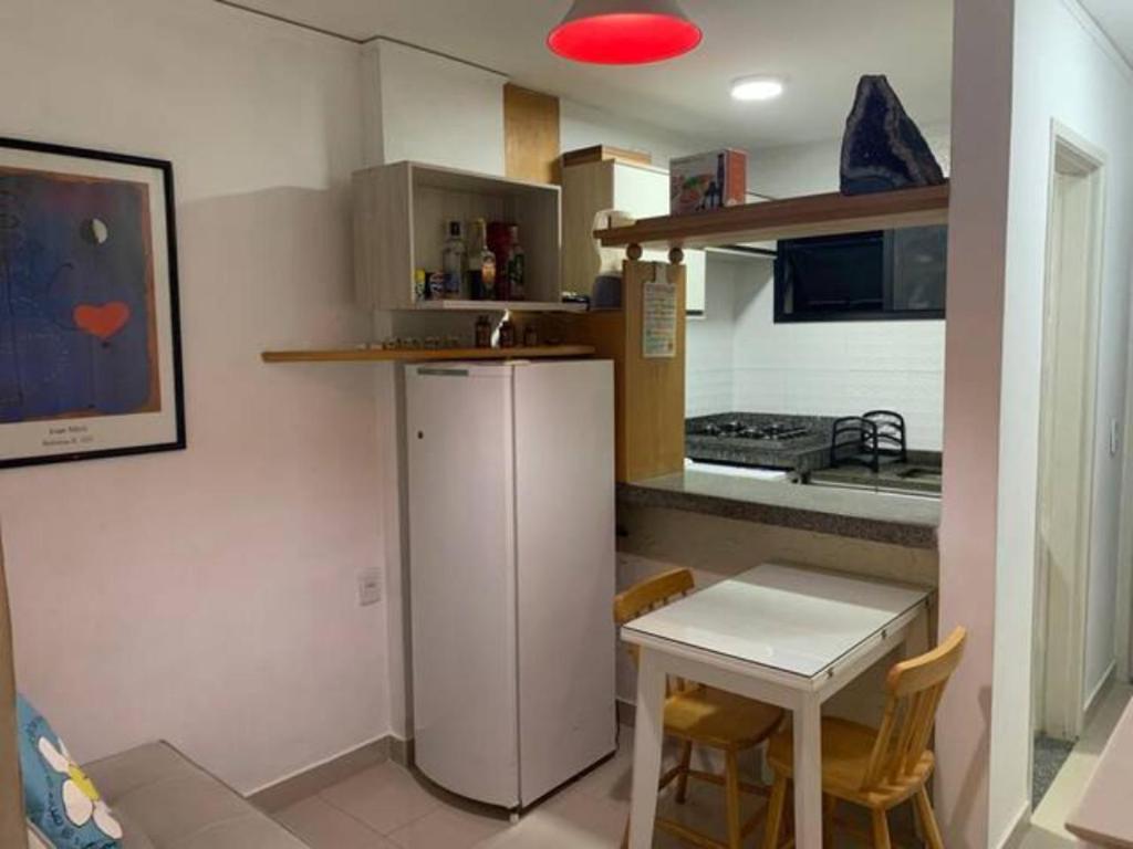 维多利亚Apartamento bairro Praia do Canto na Reta da Penha的小厨房配有白色冰箱和桌子