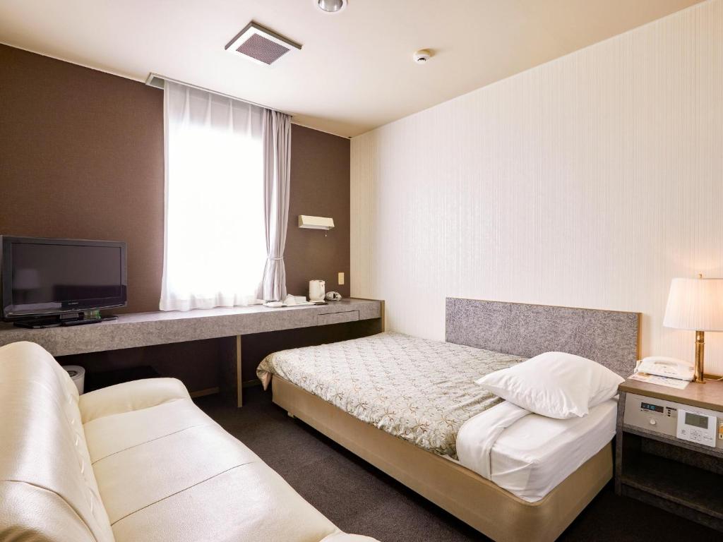对马市Hotel Tsushima - Vacation STAY 64041v的一间酒店客房,配有一张床和一台电视