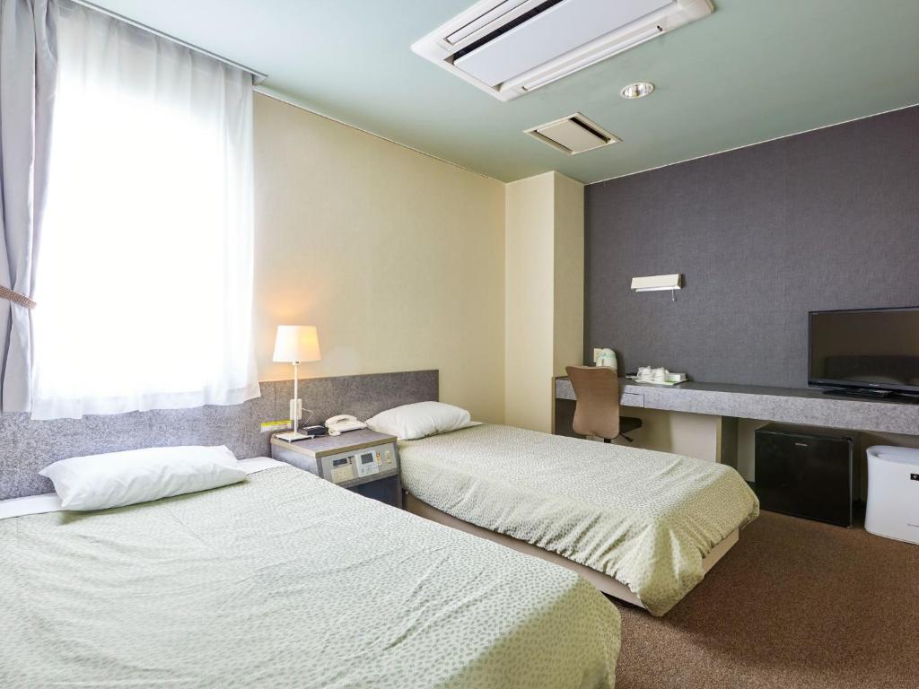 对马市Hotel Tsushima - Vacation STAY 84601v的酒店客房设有两张床和电视。