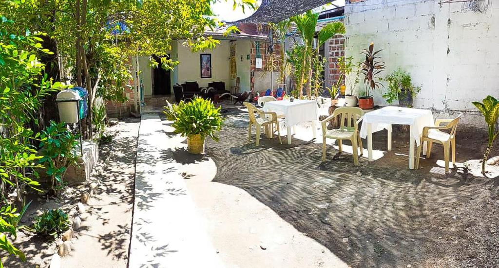 比利亚维哈Hostal Villa del Río Las Brisas的庭院配有白色的桌椅和桌椅。