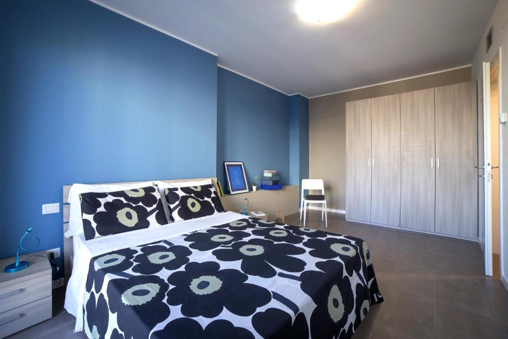 米兰米兰比可卡公寓酒店的一间卧室设有黑色和白色的床和蓝色的墙壁。