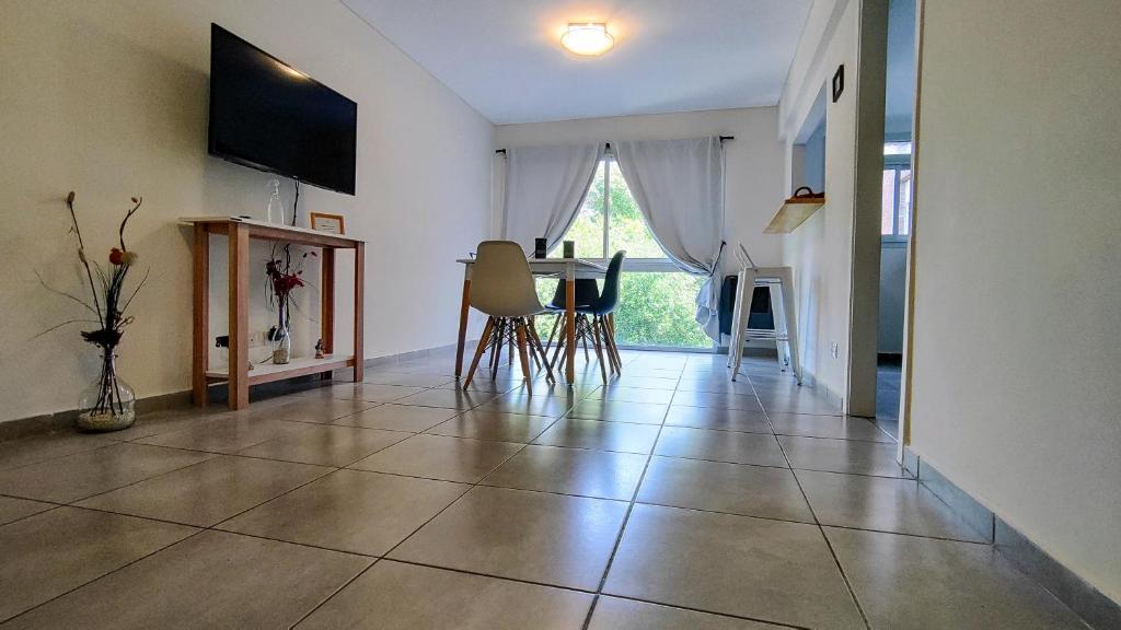 马德普拉塔Confortmdp apartamentos的客厅铺有瓷砖地板,配有桌椅