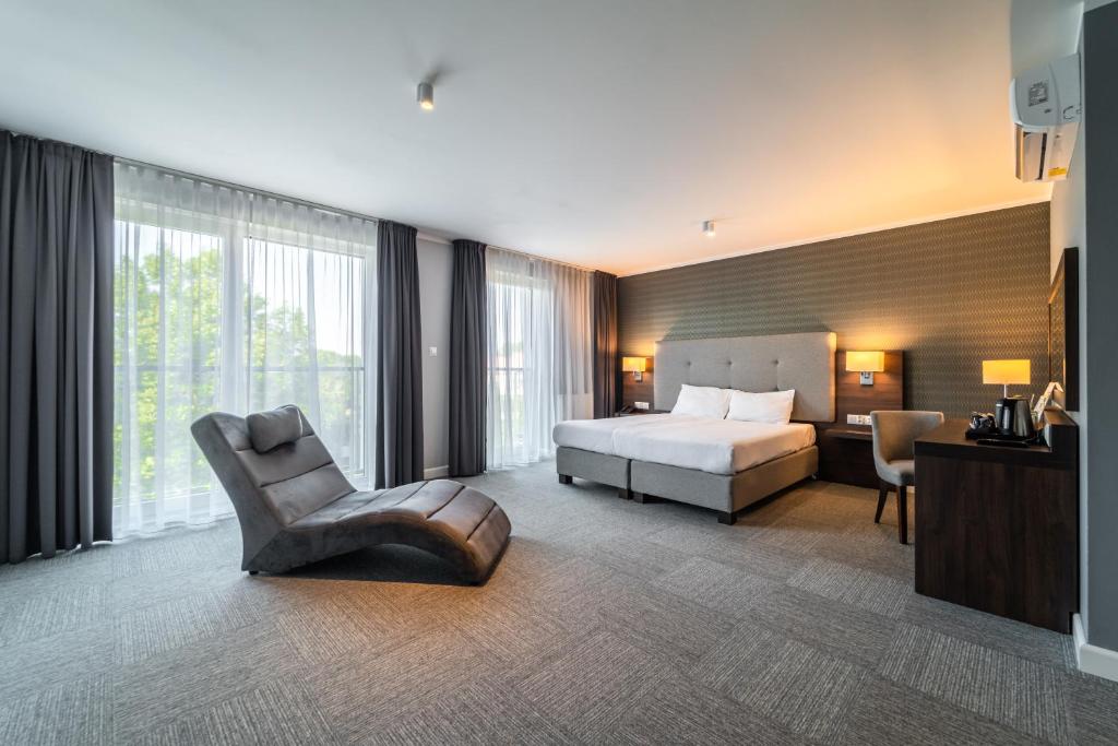 奥普尔Hotel Weneda的配有一张床和一把椅子的酒店客房
