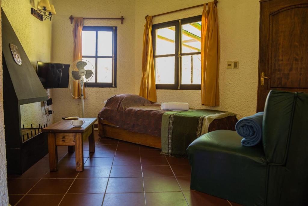 贝拉维斯塔Bellamar Apart Hotel的卧室配有床、椅子和窗户。