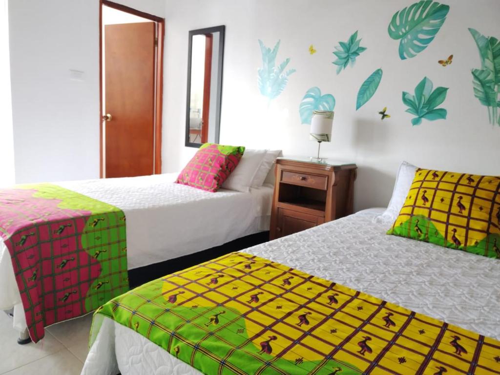 基布多Etnias Hotel tematico的一间卧室配有两张带彩色床单的床。