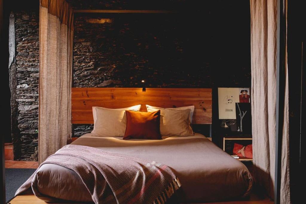 瓦隆古Porto Natura Loft的卧室配有一张大床,提供棕色床单和枕头。