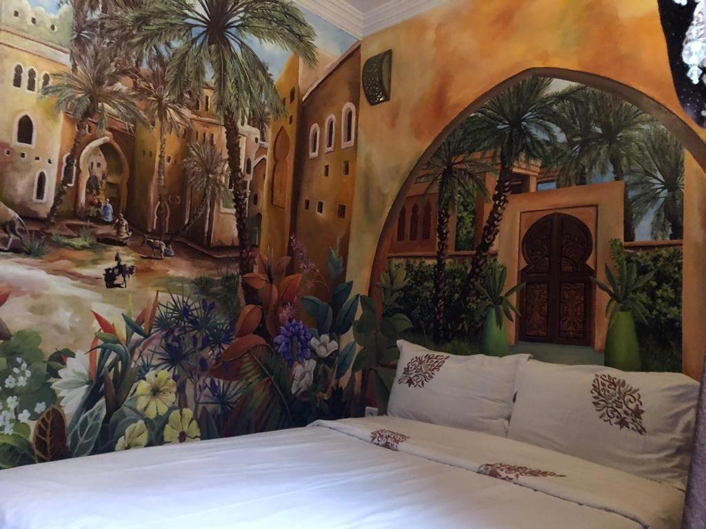 马拉喀什riad rose eternelle的卧室墙上有绘画作品