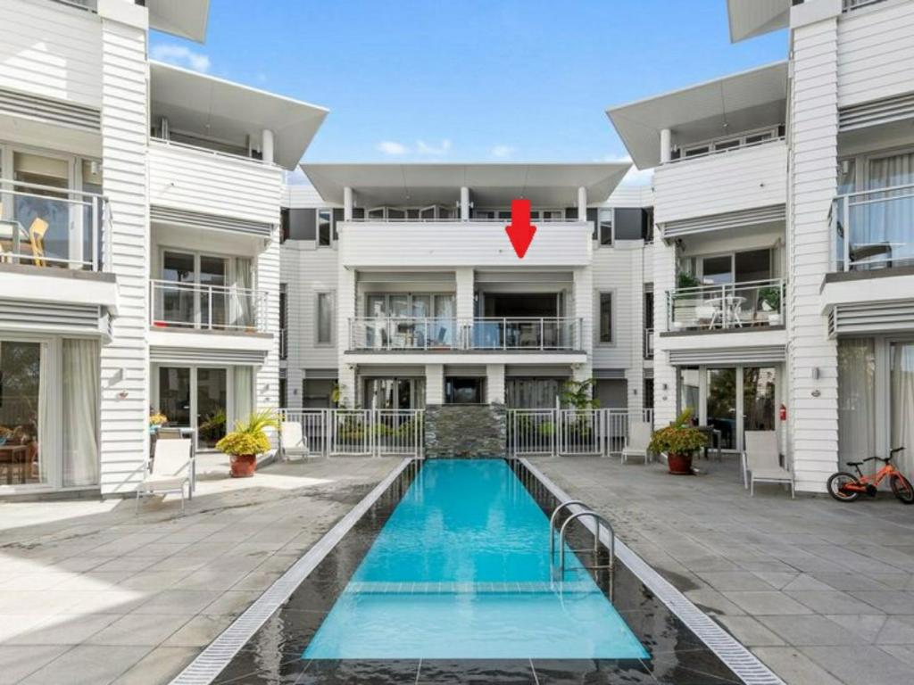 派西亚The Waterfront - Paihia Holiday Apartment的建筑前的一座带游泳池的建筑