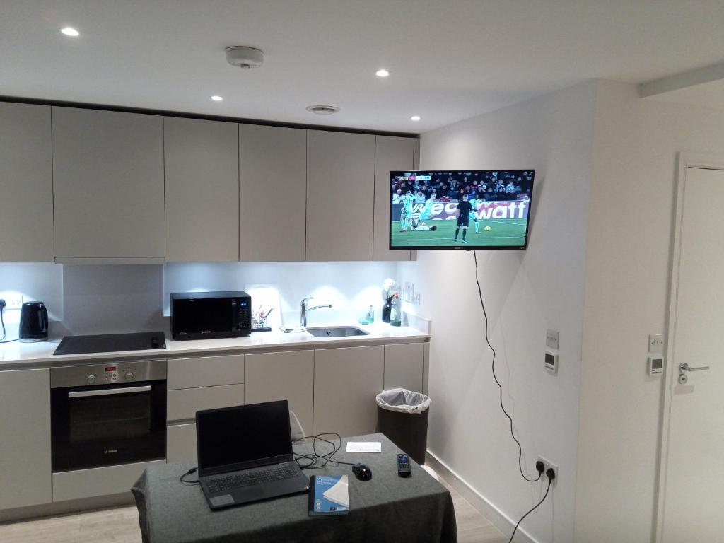 克罗伊登23 floor studio for work 1Gb WiFi的厨房设有挂在墙上的电视