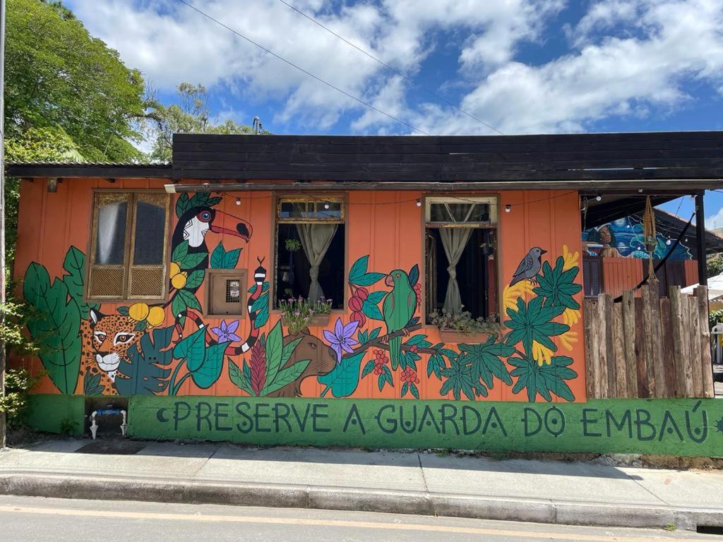 瓜尔达恩巴Hostel Antônio Pescador Guarda do Embau的一面有画的建筑物