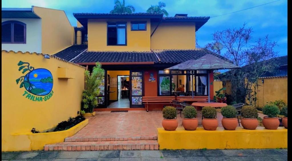 莫雷蒂斯Pousada Trilha da Serra的前面有盆栽植物的黄色房子