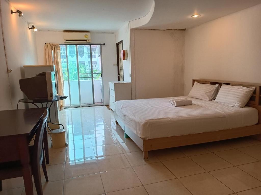 曼谷OYO 75417 Grandview Condominia的一间卧室配有一张床,并在一间客房内配有电视。