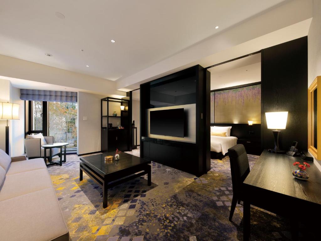 金泽金泽山乐酒店的一间客厅,客厅内配有一张床和一台电视