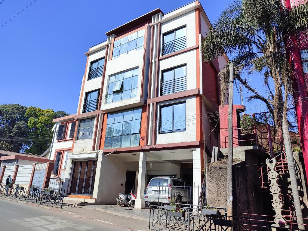 塔那那利佛Valiha Serviced Apartments Antananarivo的前面有停车位的建筑