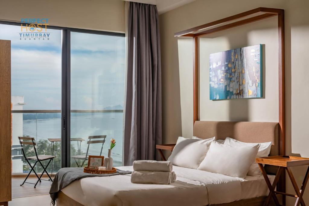 关丹Timurbay Beachfront by Perfect Host的酒店客房设有一张床和一个阳台。