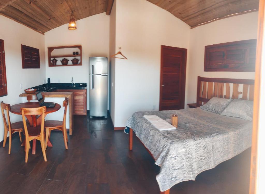 福廷Bangalô pontal beach house的配有床和桌子的房间以及厨房