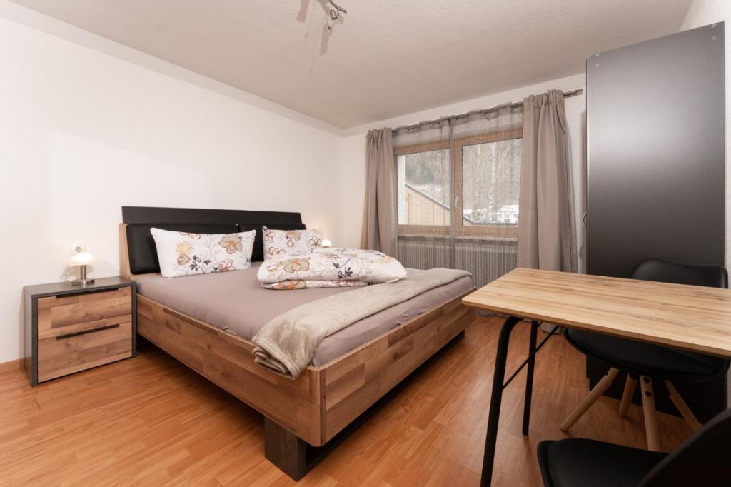 乌姆豪森Apart Ronja的一间卧室配有一张带书桌的床和窗户。