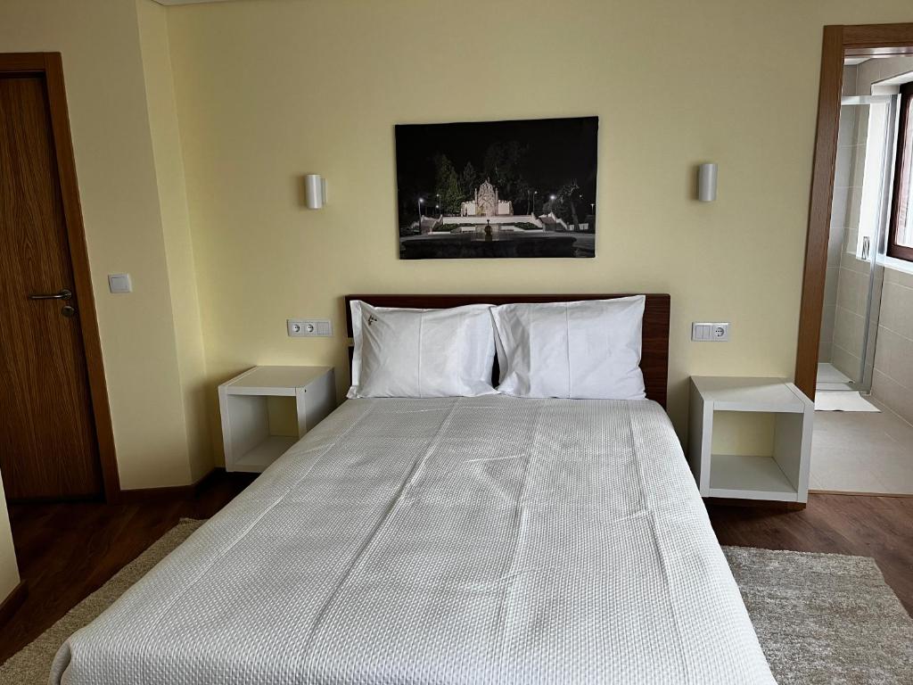 瓜尔达Aliança Alojamento Local的一间卧室配有一张带两个白色枕头的大床