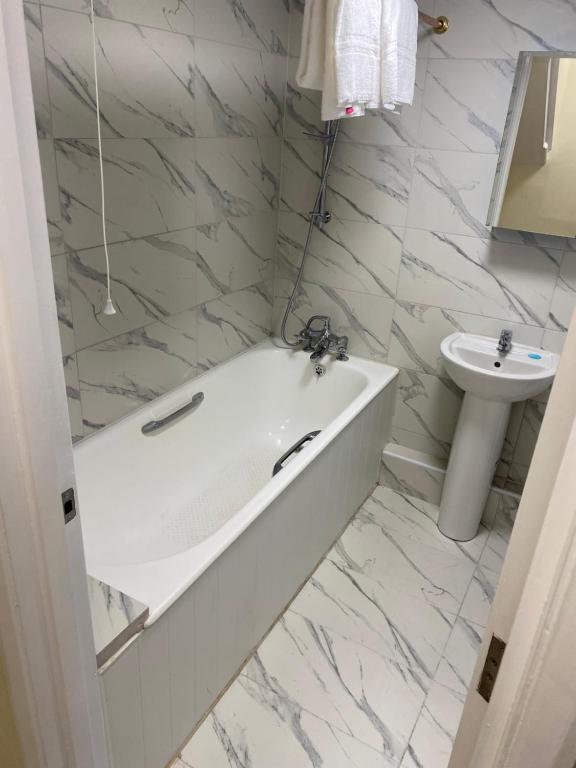 伦敦27 Argyle Square的白色的浴室设有浴缸和水槽。