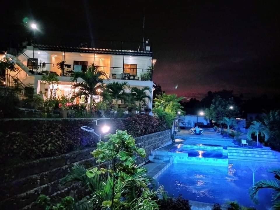 塔奈Casa de Robles Tanay Rizal的一座晚上设有游泳池的房子