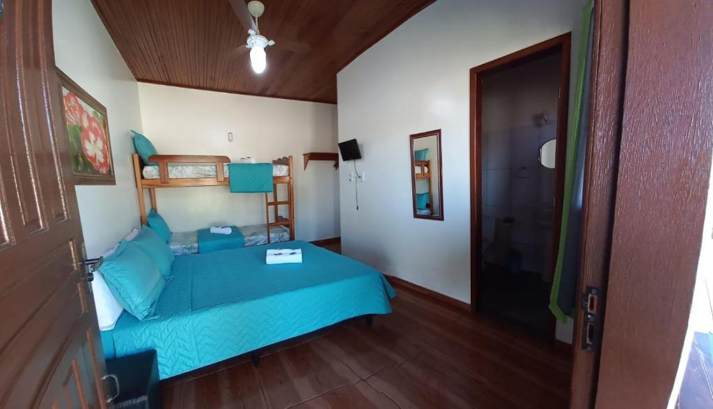 萨夸雷马Pousada Baía do Sol Vilatur的一间卧室设有蓝色的床,铺有木地板。