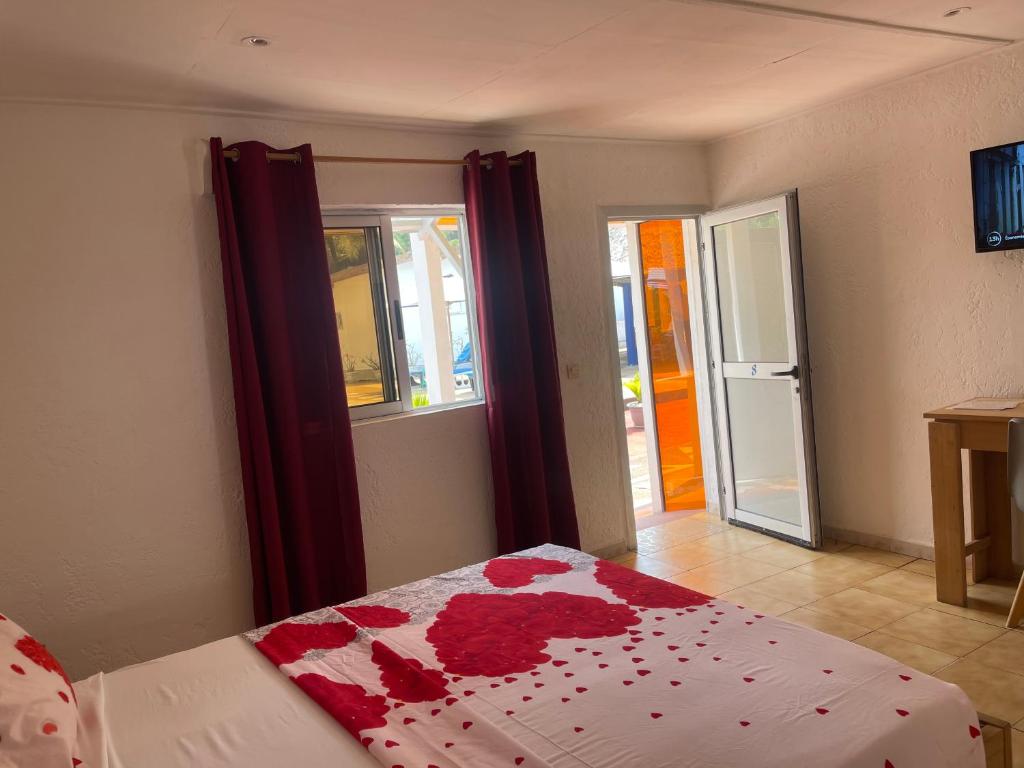 大巴萨姆Hotel La Madrague的一间卧室,床上有红色的鲜花