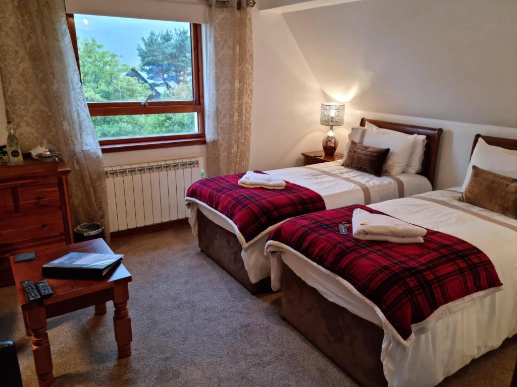 阿勒浦Lochview Guest House的酒店客房设有两张床和窗户。