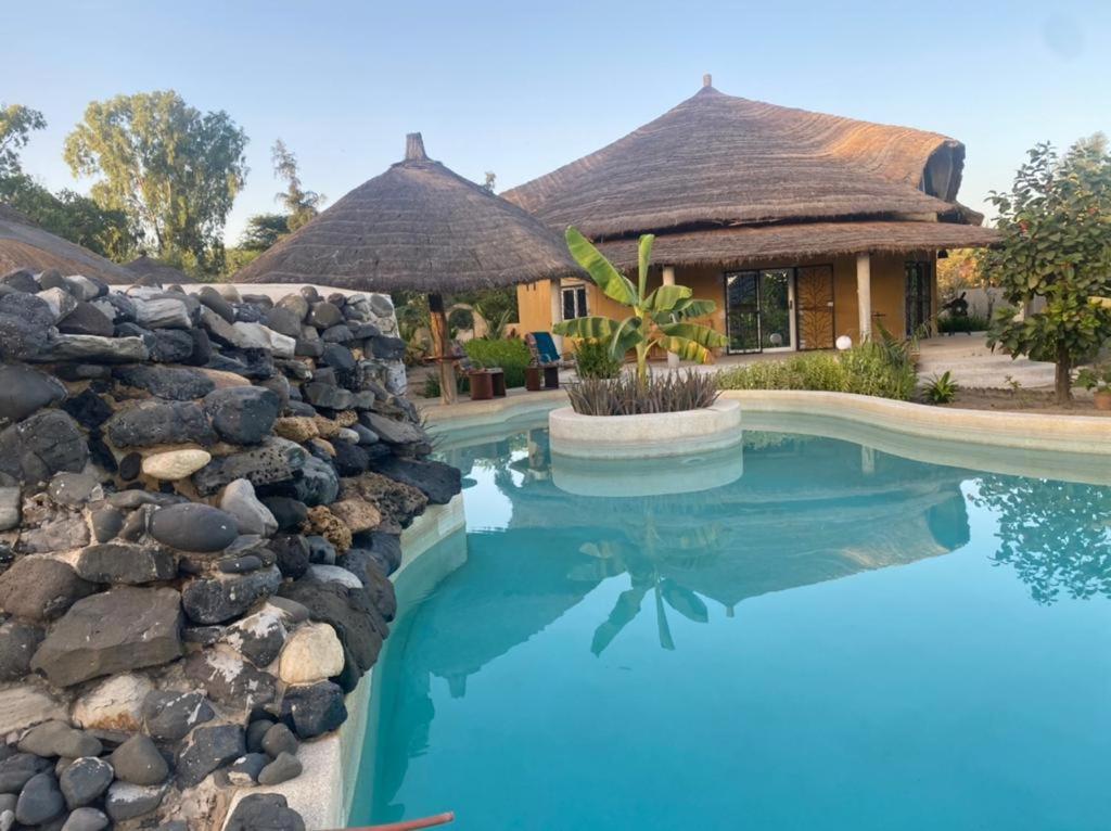 NdanganeVilla avec piscine à Ndangane的一座带游泳池和石墙的房子