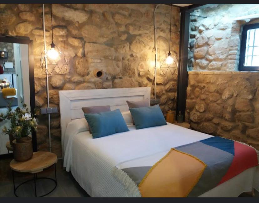 安度亚尔La Bodega的卧室配有一张石墙内的大床