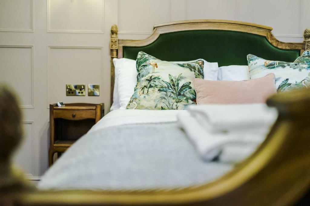 兰迪德诺Russell Court by Orenda-Luxe的一张带绿色床头板和枕头的床