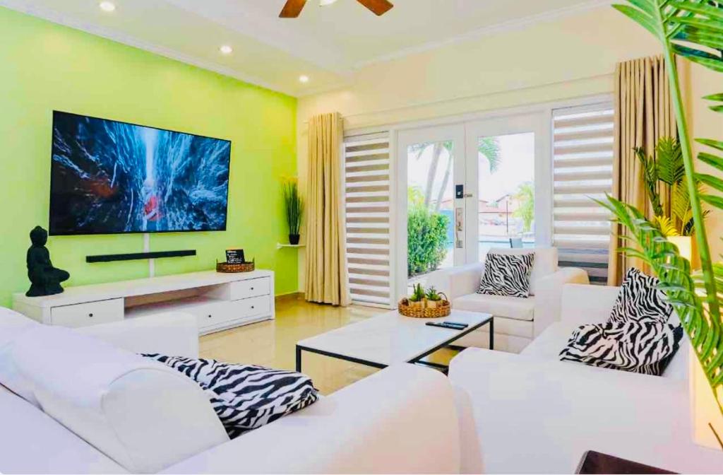 棕榈滩Eagle Beach Aruba Breeze Condominium Lime的客厅配有白色家具和平面电视