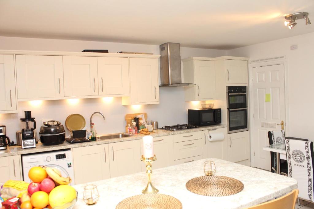 Spinney HillElegant Guest House的厨房配有白色橱柜和水果柜台。