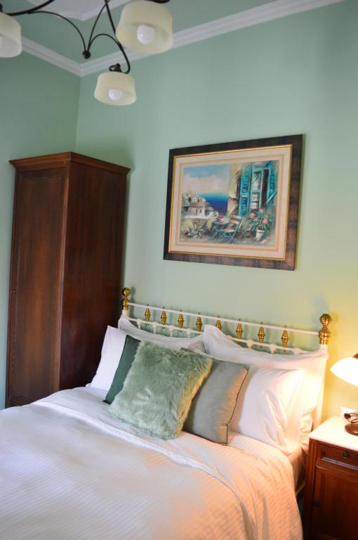 阿尔加拉斯蒂Αρχοντικό Ταξίμι (Μουντζουρίδη)的卧室配有白色的床和木制床头板