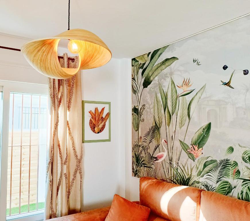 萨阿拉德洛斯阿图内斯Casa Bakara Zahara beach的客厅配有沙发和墙上的绘画