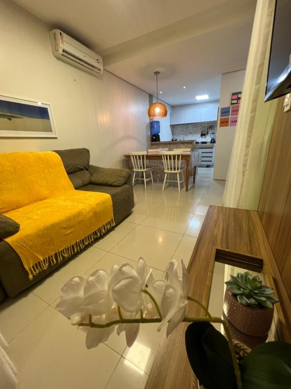 巴雷里尼亚斯Casa em Condomínio agradável com fundo pro rio的客厅配有黄色的沙发和桌子