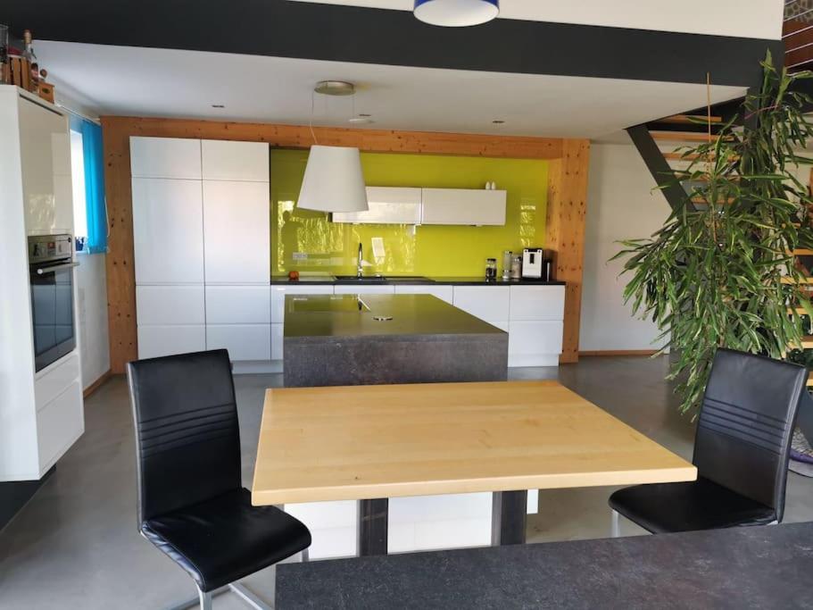 比格兰Bungalow mit 200 qm Wohnfläche :)的厨房配有木桌和黑色椅子