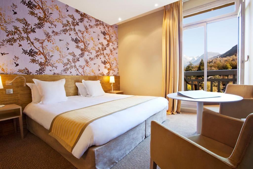 布里德莱班Grand Hôtel des Thermes Brides-les-Bains的酒店客房设有床和窗户。