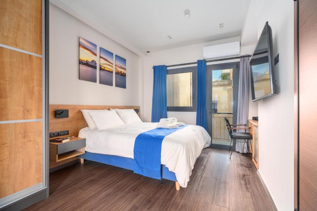 雅典Exarchia House Project的一间卧室配有一张带蓝色窗帘的大床